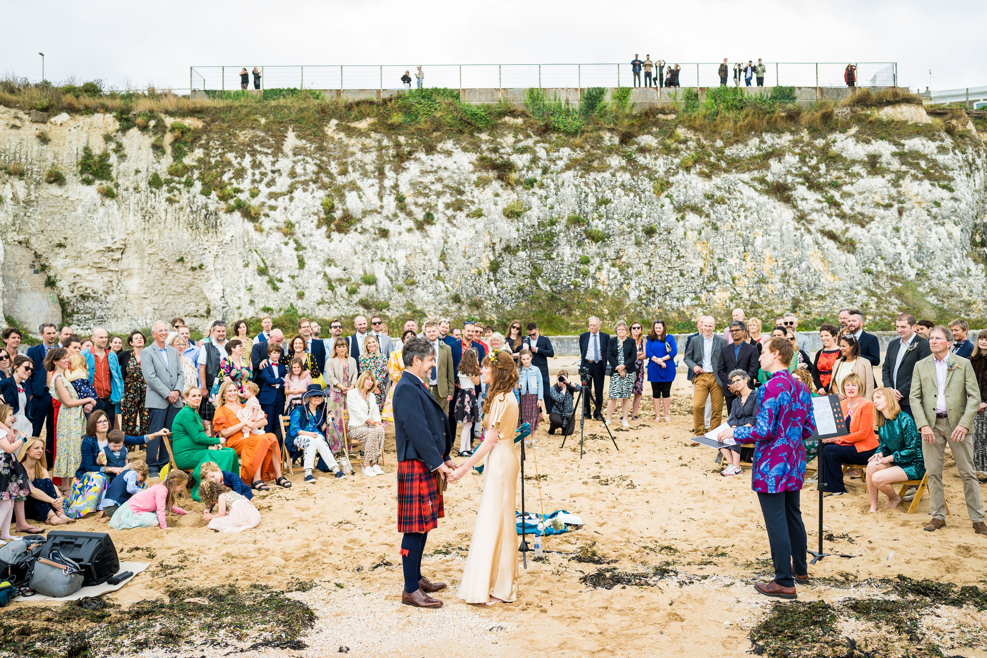 A relaxed wedding on a beach overlooked by passers by on the clifftop above. Image credit Benjamin Toms, Kent