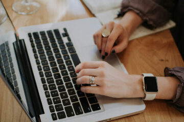 Hands typing on a laptop