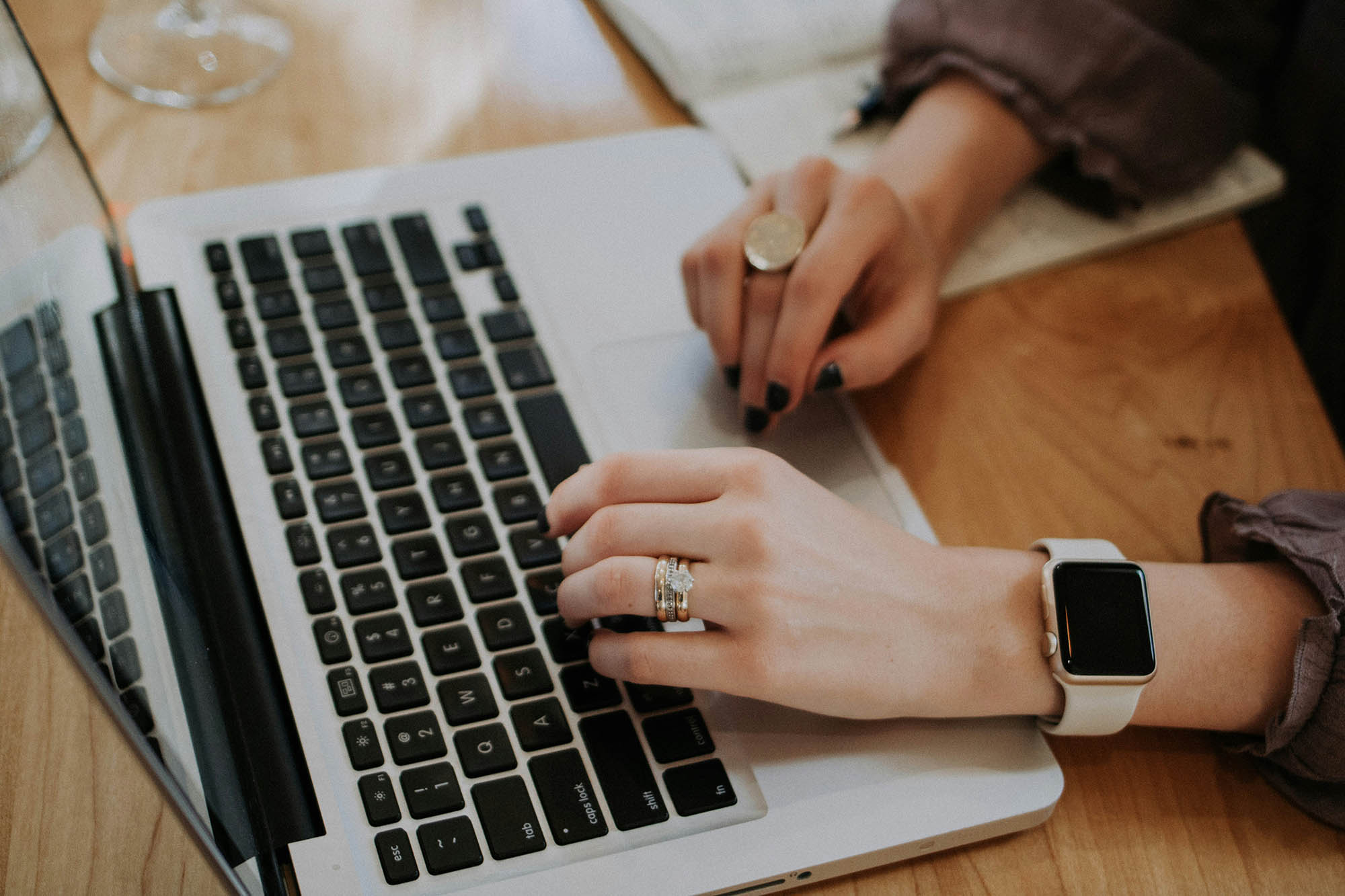 Hands typing on a laptop