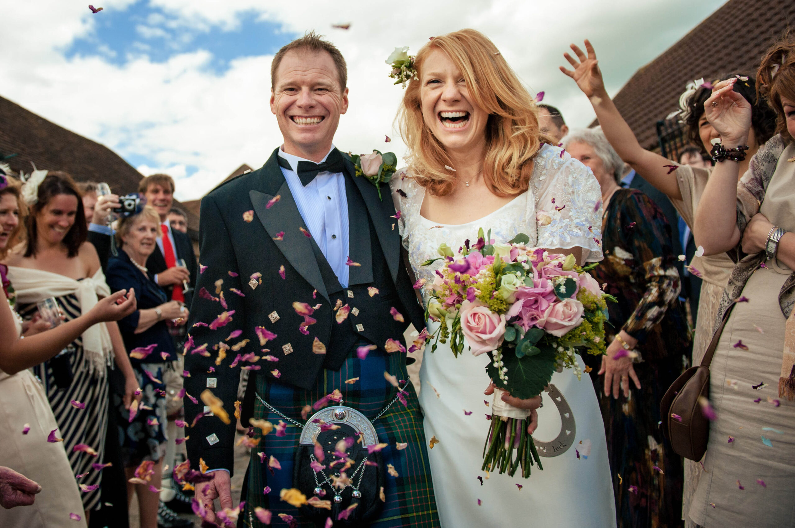 Couples laughing as guests throw confetti