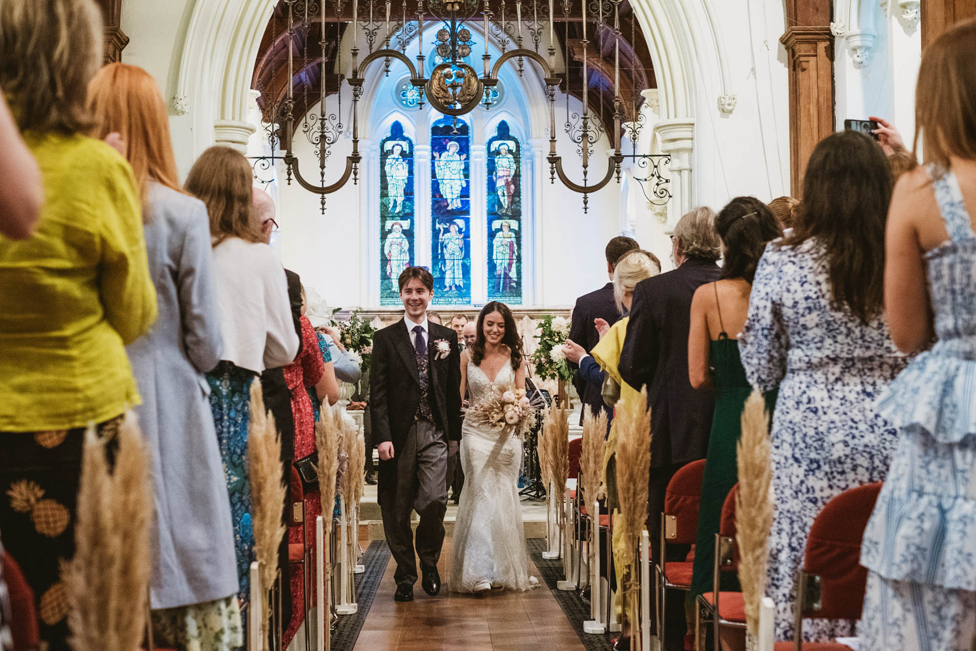 An authentic, unposed wedding image from High Billinghurst Farm with guests smiling Sophie and Chris's wedding day in Surrey. By wedding photographers and videographers York Place Studios