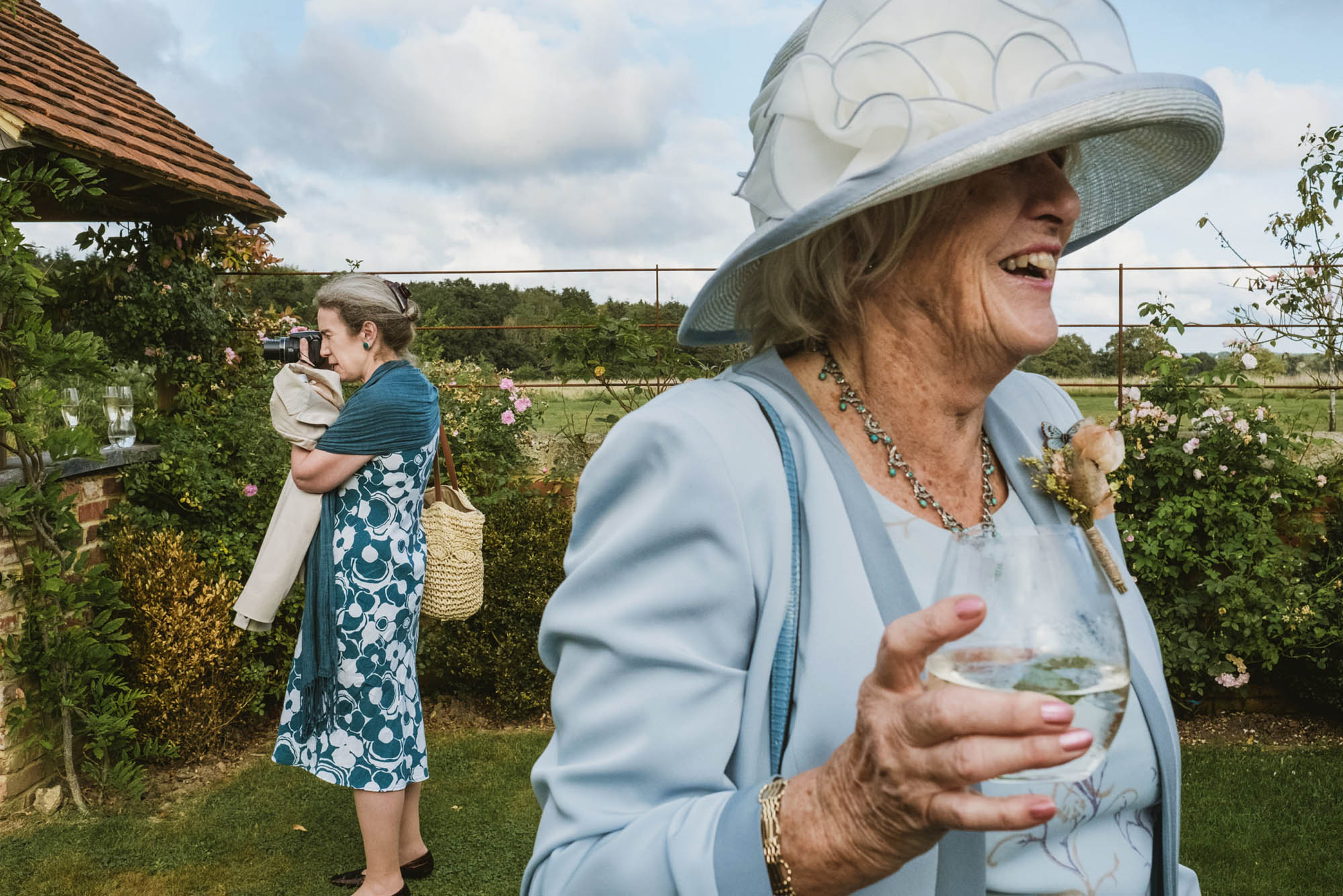 An authentic unposed wedding image with guests enjoying Sophie and Chris's wedding day in Surrey. By York Place Studios who are London and UK documentary photographers