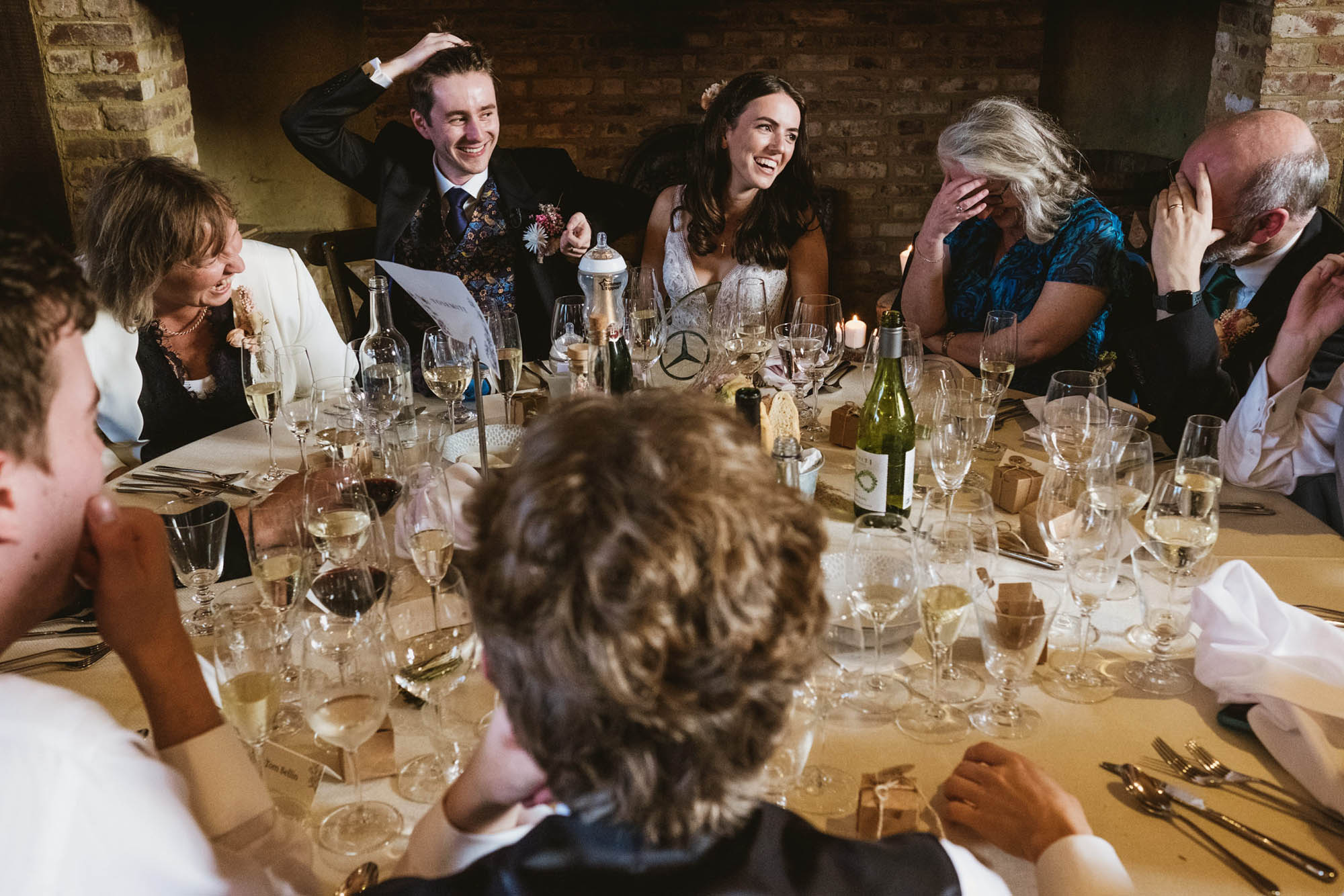 An authentic, unposed wedding image from High Billinghurst Farm with guests smiling Sophie and Chris's wedding day in Surrey. By wedding photographers and videographers York Place Studios