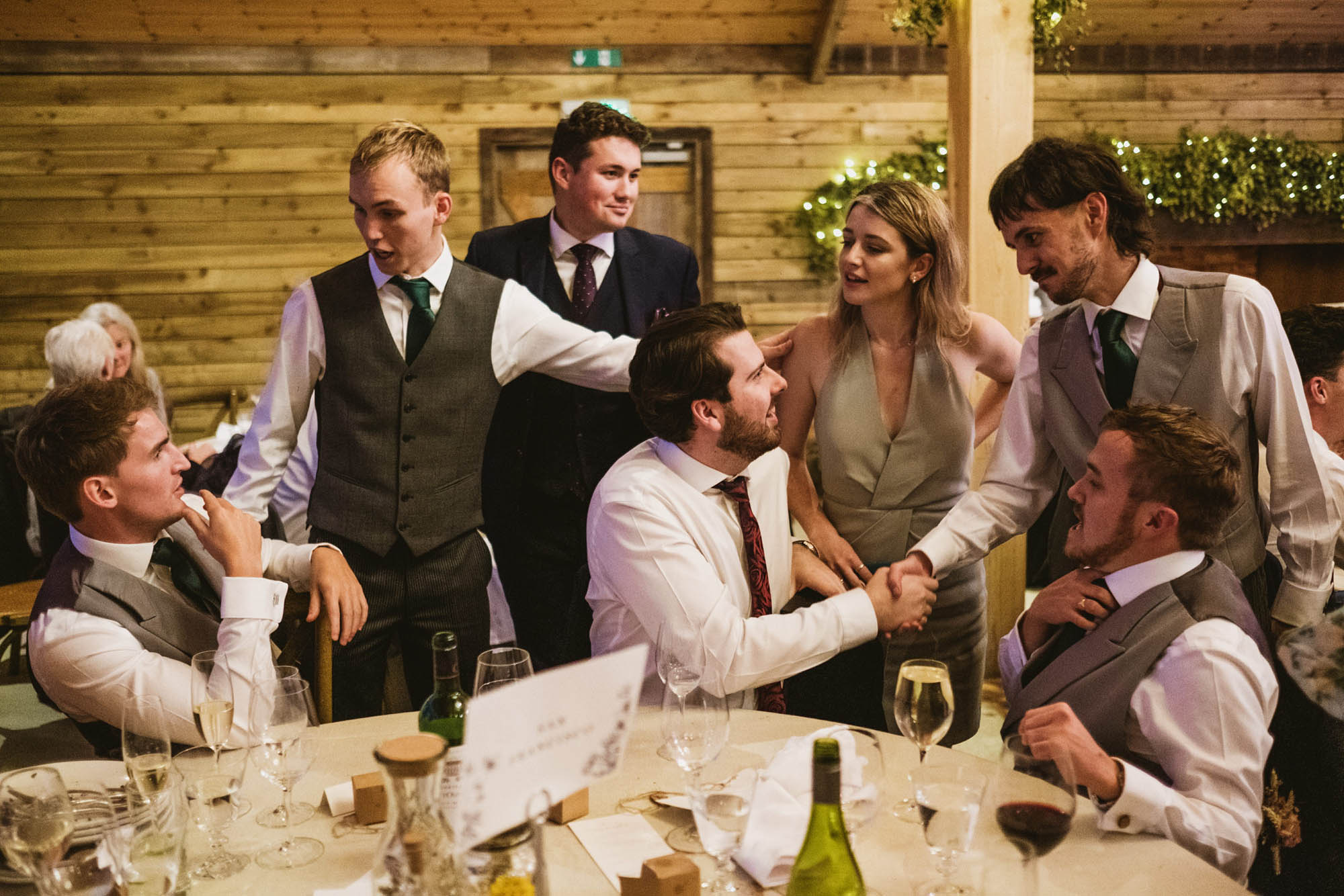 An authentic, unposed wedding image from High Billinghurst Farm with guests smiling Sophie and Chris's wedding day in Surrey. By wedding photographers and videographers York Place Studios