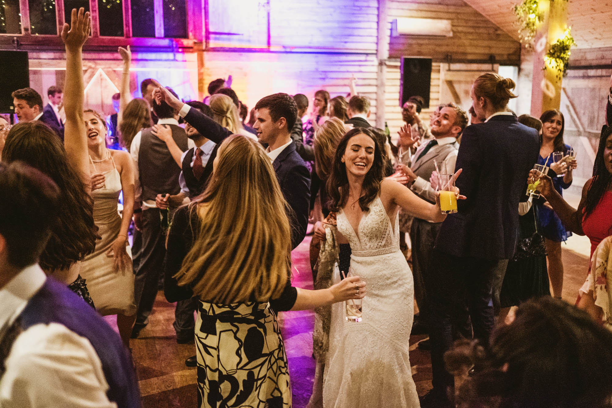 An authentic, unposed wedding image from High Billinghurst Farm in Surrey with guests enjoying Sophie and Chris's wedding day in Surrey. By York Place Studios who are London based documentary wedding photographers