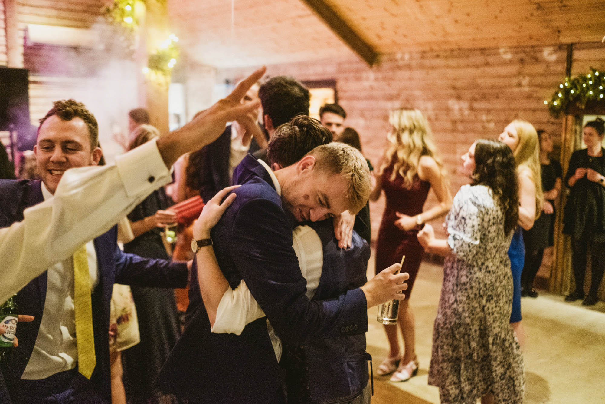An authentic, unposed wedding image from High Billinghurst Farm in Surrey with guests enjoying Sophie and Chris's wedding day in Surrey. By York Place Studios who are London based documentary wedding photographers