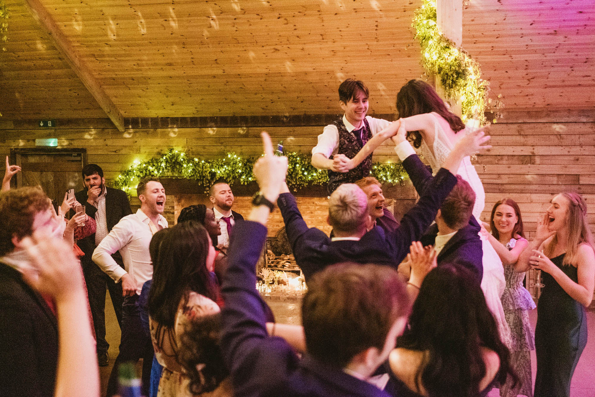 A natural wedding photo with guests enjoying Sophie and Chris's wedding day in Surrey. By York Place Studios who are London and UK award winning documentary photographers