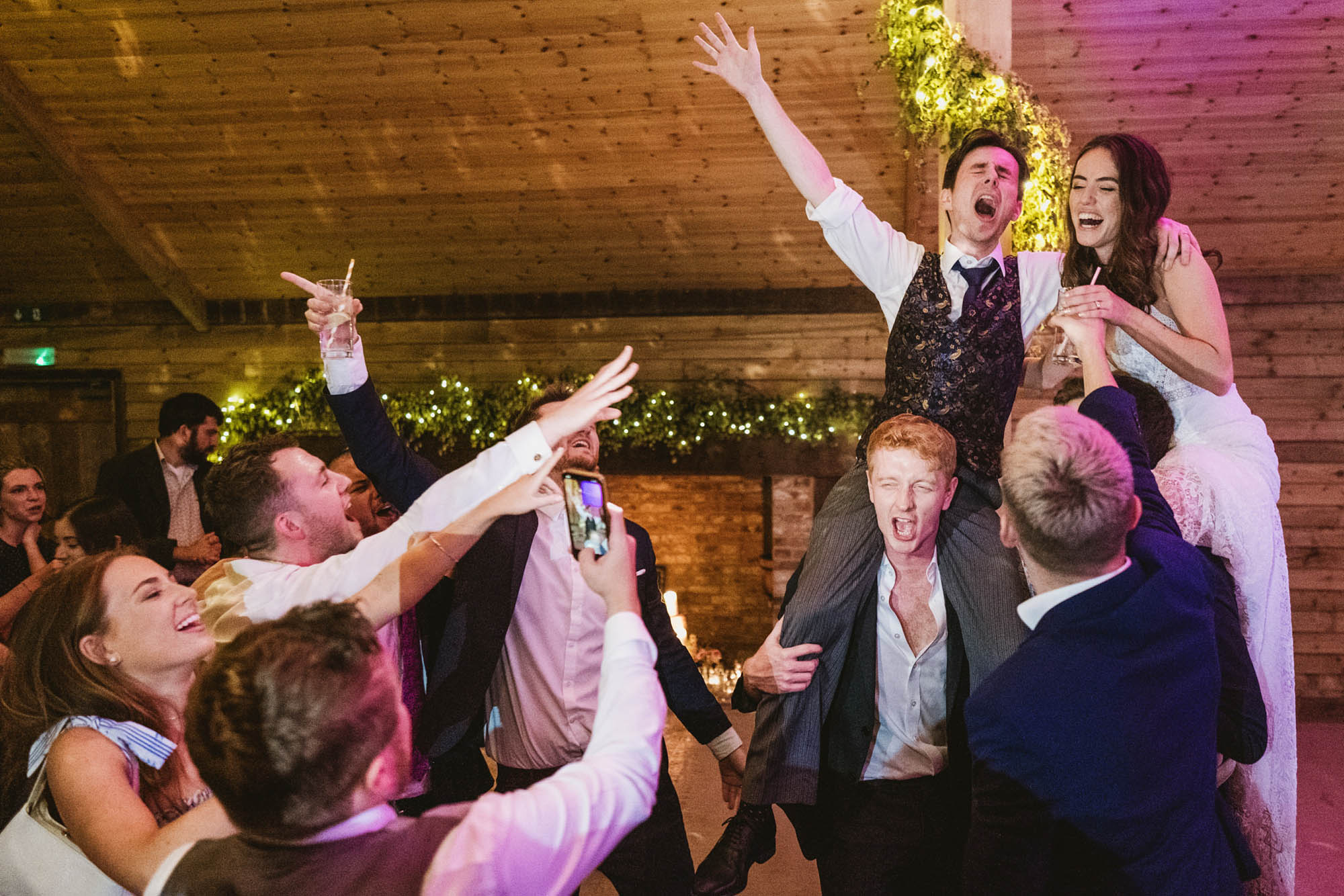 An authentic, unposed wedding image from High Billinghurst Farm in Surrey with guests enjoying Sophie and Chris's wedding day in Surrey. By York Place Studios who are London based documentary wedding photographers